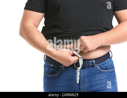 Homme en surpoids mesurant sa taille sur fond blanc. Concept de perte de poids Banque D'Images