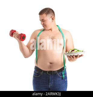 Homme en surpoids avec haltère, salade et ruban de mesure sur fond blanc. Concept de perte de poids Banque D'Images