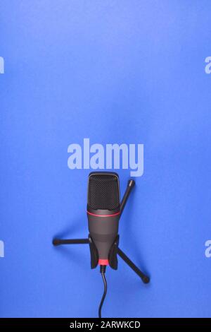 Un microphone pour créer un son professionnel et la production de podcast. Sur un fond bleu avec espace de copie. Vue sur le dessus, plat. Banque D'Images