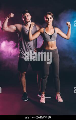 Jeune couple sportif sur fond sombre Banque D'Images