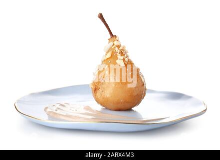 Assiette avec une délicieuse poire cuite sur fond blanc Banque D'Images