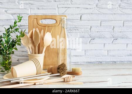 ustensiles écologiques sur fond en bois sur mur de briques blanches. . Vaisselle, brosses, cuillères et bouteilles. Concept zéro déchet. Banque D'Images