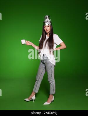 Jolie jeune femme portant un chapeau de toinfoil pour la protection. Concept de théorie du complot. Banque D'Images