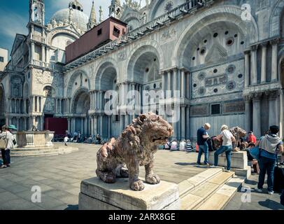 Venise, Italie - 19 mai 2017 : l'ancien lion de pierre se trouve sur la place Saint Marc (Piazza San Marco). Basilique Saint-Marc en arrière-plan. C'est TH Banque D'Images