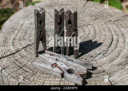 Vieux piquets de vêtements en bois vieillés sur vieux tronc d'arbre taillé surface closeup Banque D'Images