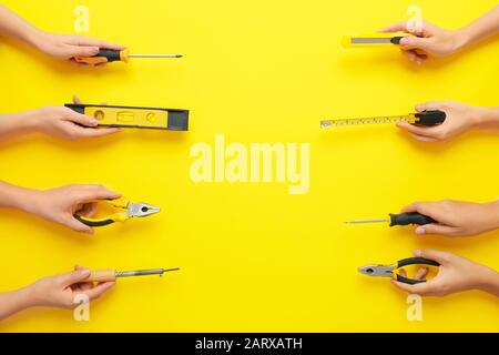 Mains féminines avec jeu de fournitures d'électricien sur fond couleur Banque D'Images