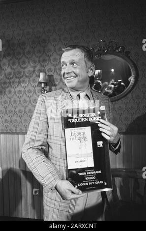 Show Hermans reçoit d'Eli Asser le Livre d'or pour 100 000 exemplaires De Mentir dans l'herbe Show Hermans montre fièrement le Livre d'or Date: 8 mars 1979 mots clés: Livres, cabaretiers, portraits Nom personnel: Hermans, Show Banque D'Images