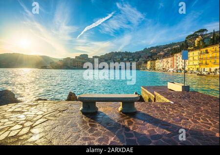 Banc en bord de mer dans le port de Porto Santo Stefano au lever du soleil, Monte Argentario, Maremma, Toscane, Italie. Banque D'Images