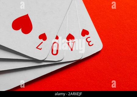 Word Love composé de cartes de jeu sur fond couleur Banque D'Images