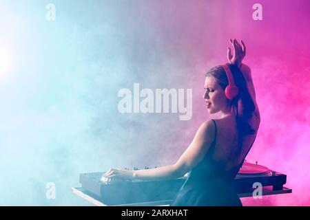 DJ féminin jouant de la musique dans la discothèque Banque D'Images