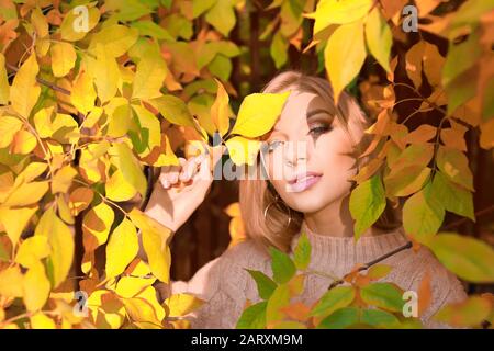 Belle jeune femme près de l'arbre d'automne dans le parc Banque D'Images