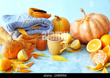 Belle composition d'automne avec tasse de thé, agrumes, confiture savoureuse et sweaters sur fond de couleur Banque D'Images