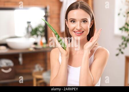 Belle jeune femme avec aloe vera dans la salle de bains Banque D'Images