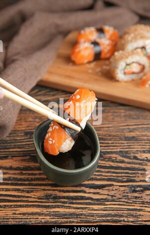 Trempez de délicieux sushis dans de la sauce soja Banque D'Images