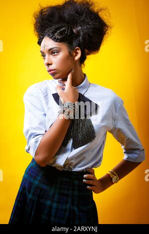 Jeune fille intelligente portrait sur un fond jaune Banque D'Images