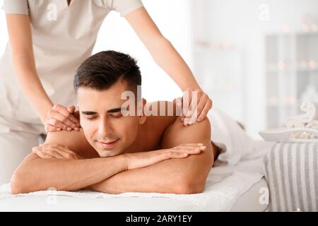 Bel homme ayant massage au spa salon Banque D'Images