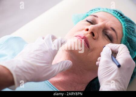 Visite de la vieille femme homme médecin pour la chirurgie en plastique Banque D'Images