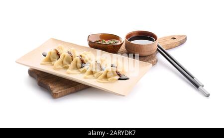 Assiette avec de délicieuses sauces de gyoza japonaises sur fond blanc Banque D'Images