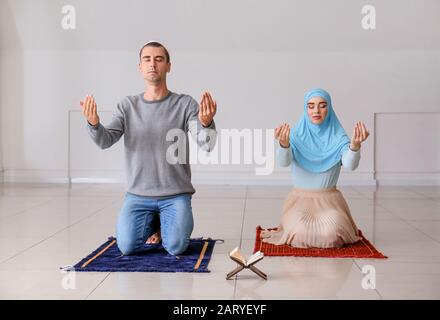 Couple musulman priant dans la chambre Banque D'Images