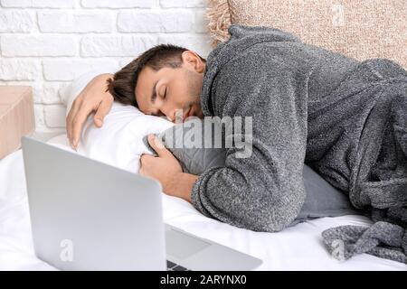 Bel homme en peignoir dormant sur le lit Banque D'Images