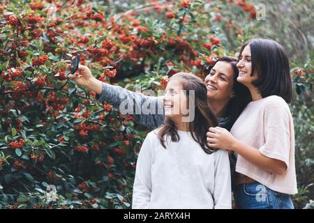 Mère et filles souriant et prenant le selfie Banque D'Images