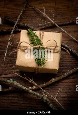 Fronde de pin attachée au cadeau de Noël à côté des bâtons Banque D'Images