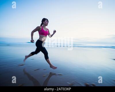 Young woman running on beach Banque D'Images