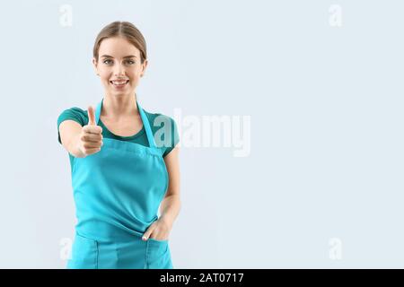 Concierge montrant le pouce vers le haut sur fond clair Banque D'Images