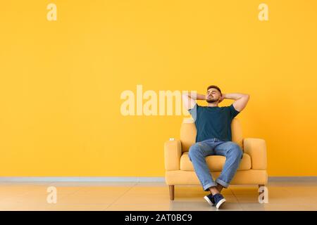 Jeune homme se reposant dans la chambre avec climatiseur Banque D'Images