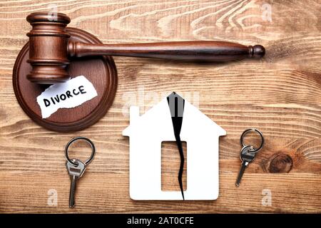 Le gavel du juge, figure de la maison avec des fissures et des clés sur fond de bois. Concept de divorce Banque D'Images