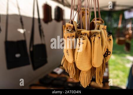 Articles en cuir faits à la main dans une boutique d'artisanat sur le marché local de l'agriculteur.gros plan de petits sacs ou bourses de couleur naturelle avec franges et décorations. Banque D'Images