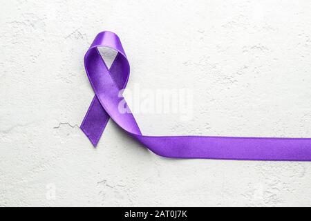 Ruban violet comme symbole de la Journée mondiale du cancer sur fond clair Banque D'Images