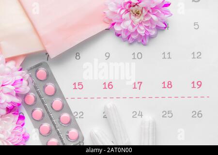 Calendrier menstruel avec des produits et des pilules féminines, vue de dessus Banque D'Images