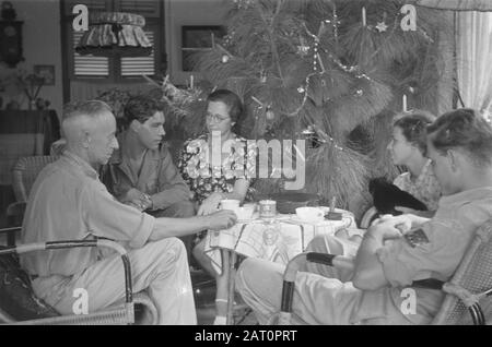 Fleurs pour la célébration des morts et de Noël à Semarang une compagnie autour d'une table près d'un arbre de Noël décoré Date: 25 décembre 1947 lieu: Indonésie, Pays-Bas Indes de l'est Banque D'Images