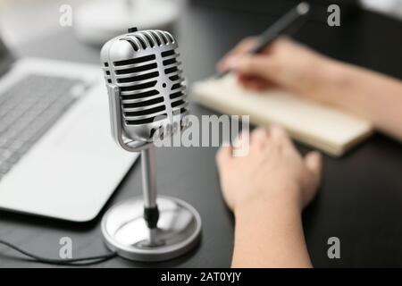 Journaliste féminine avec microphone ayant une entrevue au bureau, closeup Banque D'Images