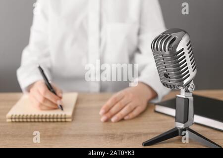 Journaliste féminine avec microphone ayant une entrevue au bureau, closeup Banque D'Images