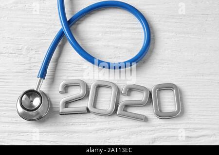 Stéthoscope et figure 2020 sur fond de bois blanc Banque D'Images