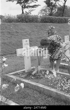 Fleurs pour la célébration des morts et de Noël à Semarang UNE femme pose des fleurs sur la tombe de H. den Hartog, soldat II-7 R.I. né 12-3-1923 mort 10-2-1947 Date: 25 décembre 1947 lieu: Indonésie, Pays-Bas Indes orientales Banque D'Images