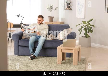 Homme avec un joli journal de lecture de chat à la maison Banque D'Images