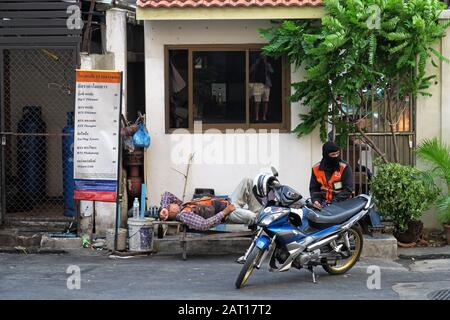 bangkok, thaïlande - 2020.01.18: les chauffeurs de taxi de moto prennent une pause tout en attendant les passagers à leur gare au bord de la route de sukhumvit 63 Banque D'Images