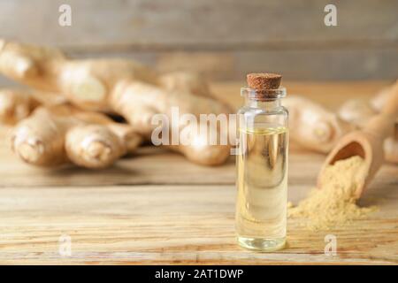 Bouteille d'huile essentielle de gingembre sur table en bois Banque D'Images