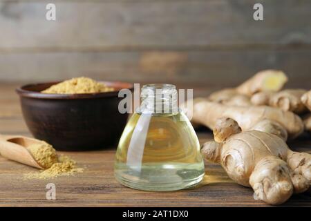 Bouteille d'huile essentielle de gingembre sur table en bois Banque D'Images