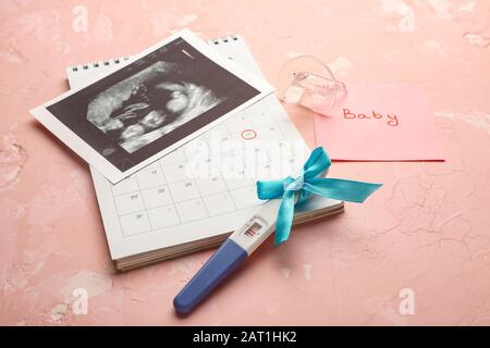 Test de grossesse, image d'échographie et calendrier sur fond couleur Banque D'Images