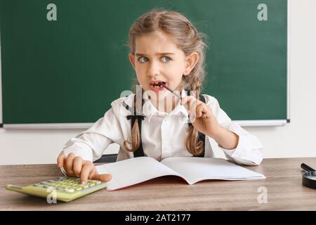 Petite écolière qui fait des tâches en classe Banque D'Images