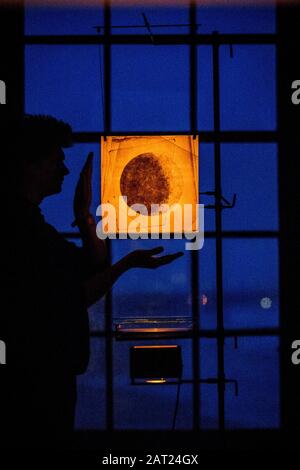 L'artiste James Russell de JAMESPLUMB se tient à côté d'un instrument optique avec une projection de lumière à travers le verre qui crée des silhouettes qui évoquent la surface lunaire, au temple de Mussenden près de Castlerock dans le comté de Londonderry, où lui et Hannah Plumb présenteront Silent Light, La toute première installation légère et l'expérience du ciel sombre, du 9 au 23 février 2020, en collaboration avec la National Trust. Banque D'Images