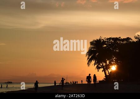 Les gens silhouettes sur la belle plage de Dumaluan au coucher du soleil sur l'île de Panglao, Bohol - Philippines Banque D'Images