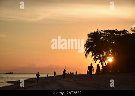 Les gens silhouettes sur la belle plage de Dumaluan au coucher du soleil sur l'île de Panglao, Bohol - Philippines Banque D'Images