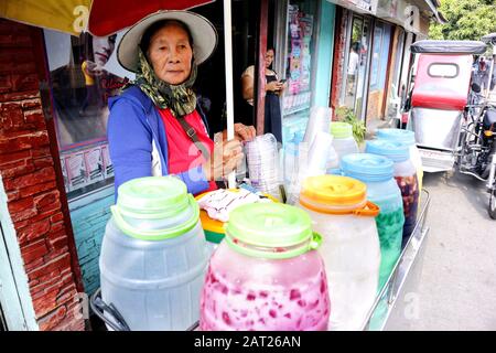 Antipolo City, Philippines - 29 janvier 2020: Le vendeur de rue vend des boissons fraîches aromatisées dans son chariot sur un trottoir. Banque D'Images