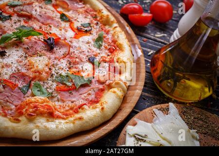 Grande pizza chaude. Composition savoureuse de pizza. Ingrédients alimentaires et épices pour la cuisine. Banque D'Images