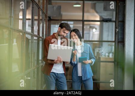 Barbu beau homme dans une chemise marron discutant de travail questions avec collègue Banque D'Images